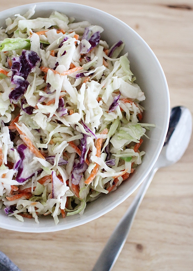 bowl of healthy coleslaw with serving spoon