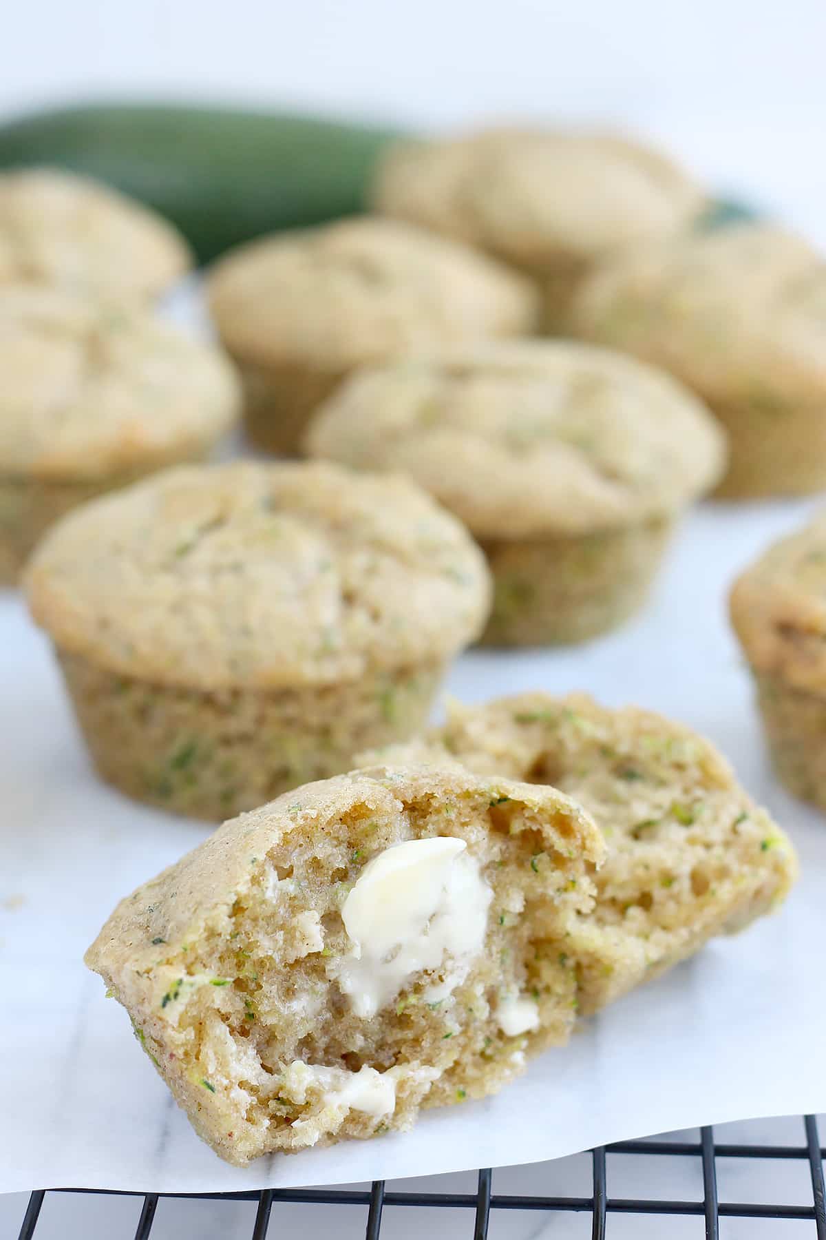 A tender zucchini muffin, split in half and spread with softened butter.